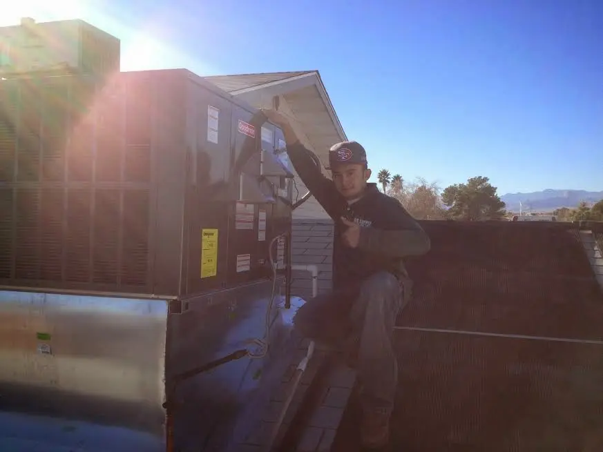 HVAC technician performing HVAC Inspection on a rooftop unit in Madison Heights